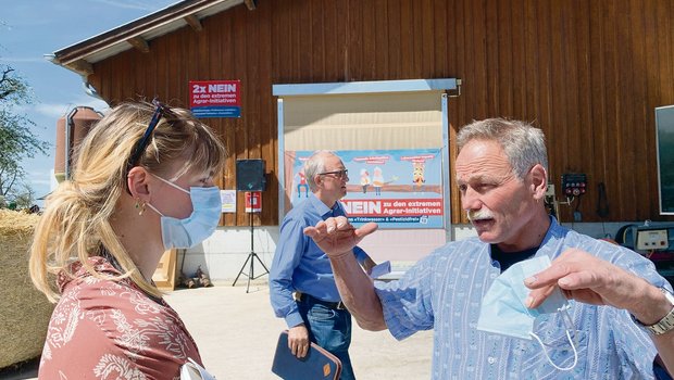 Landwirt Karl Meienberg erklärt einer Journalistin die Folgen der Pflanzenschutz-Initiativen auf seinem Bauernhof. Mitten im Bild Ständerat Peter Hegglin. (Bild Josef Scherer)