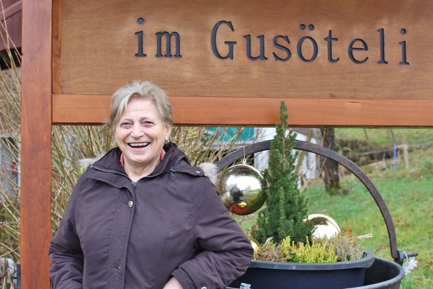 Rita Hegner vor dem schmucken Willkommensschild. Entworfen und gezimmert hat es Enkel Daniel. (Bild sbw)