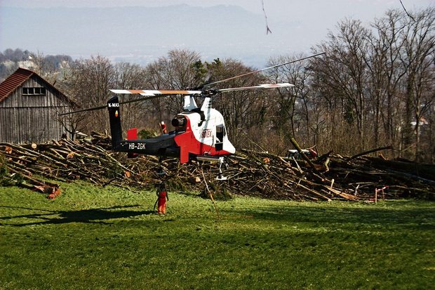 Zwischenlandung des Helikopters mit dem Übernamen «fliegenden Kran» bei Wienacht-Tobel. Er vermag mehr Gewicht zu Tragen als er Eigengewicht hat. Bäume fliegen im Appenzellerland durch die Luft. Im Hintergrund das sanktgallische Dorf Thal am Buechberg. (Bild: Hansruedi Wieser)