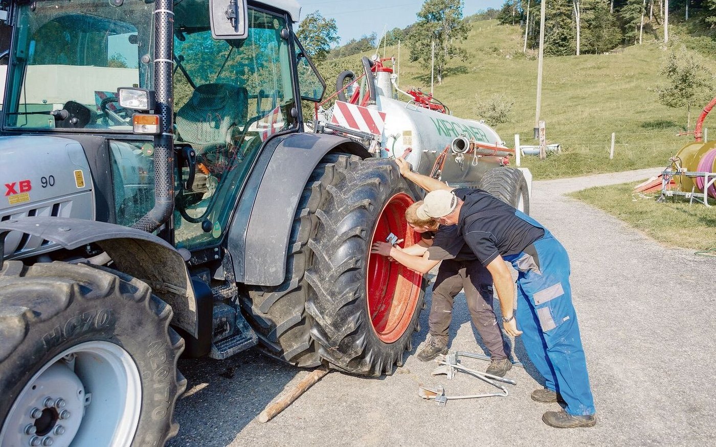 Lehrmeister instruiert Lernenden für die Montage des Doppelrades. Zufriedene Auszubildende lernen und leisten mehr, auch in der landwirtschaftlichen Lehre. 