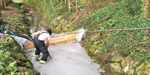 Ein Feuerwehrmann errichtet eine Sperre in einem Bach nachdem Gülle ausgelaufen ist. (Bild: Kantonspolizei Thurgau)