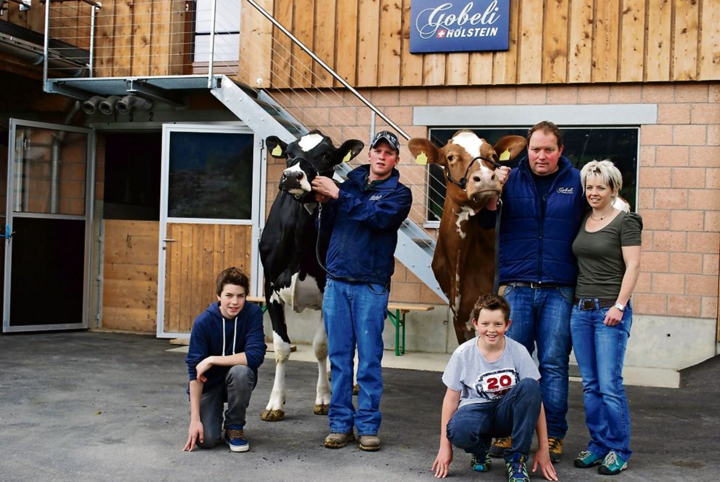 Alex und Margrit Gobeli mit den Kindern Yanik und Timo, mit der aktuellen Red-Holstein-Nationalsiegerin Jowis Incas Flavia. Links der Herdenmanager Markus von Känel mit der Swiss-Expo-Siegerin Pagewire Delicieuse. Auf dem Bild fehlt die Tochter Sabrina Gobeli und Erich Zingre. (Bild: Peter Fankhauser)