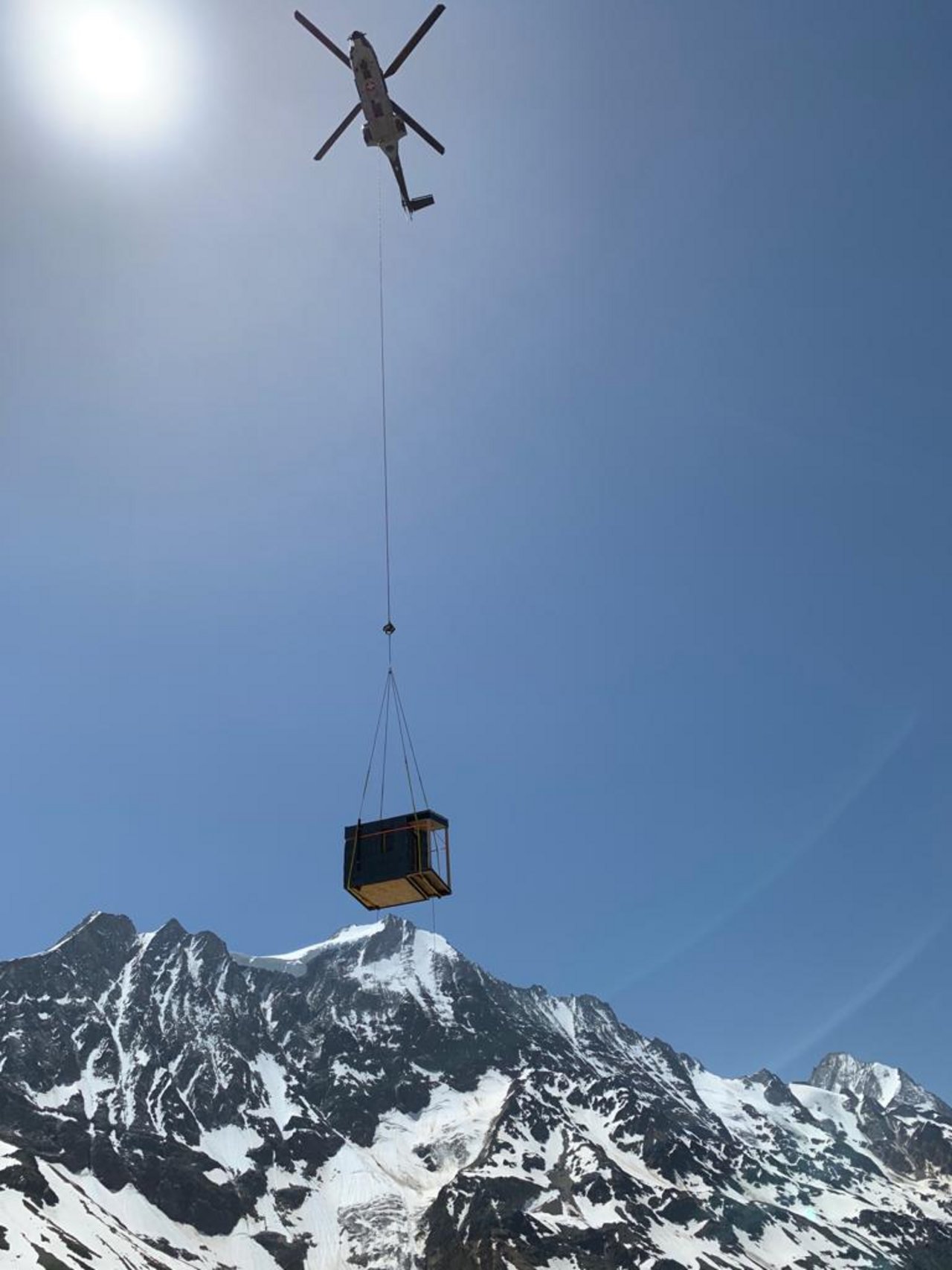 Ein Helikopter fliegt die mobile Alpunterkunft Lana auf die Alp Gugginen. Ein Helikopter fliegt die Alpunterkunft Lana auf die Alp Gugginen. (zvg/Joël Morerod)