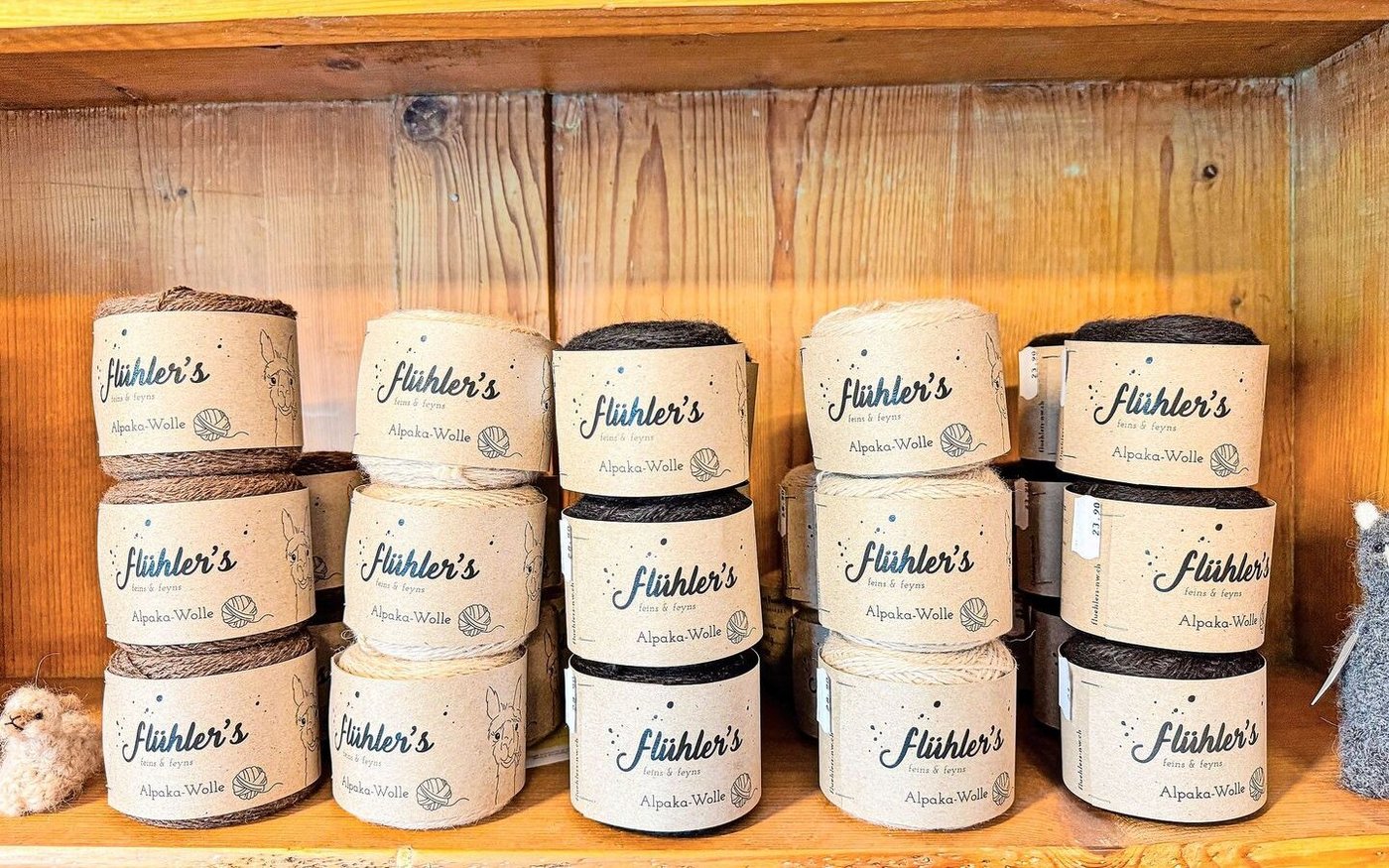 Die verschiedenfarbigen Alpaka-Wollknäuel sind alle mit dem Namen des jeweiligen Tiers beschriftet.