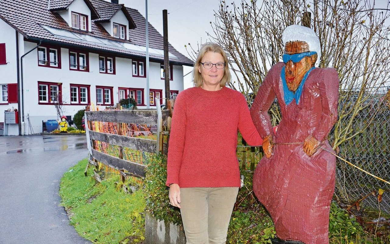 Petra Nef vor dem Wohnhaus der Familie neben einer lebensgrossen Holzfigur. Hier im Garten hat sie viele gemeinsame Stunden mit ihrer Mutter gearbeitet und Gäste bewirtet.»