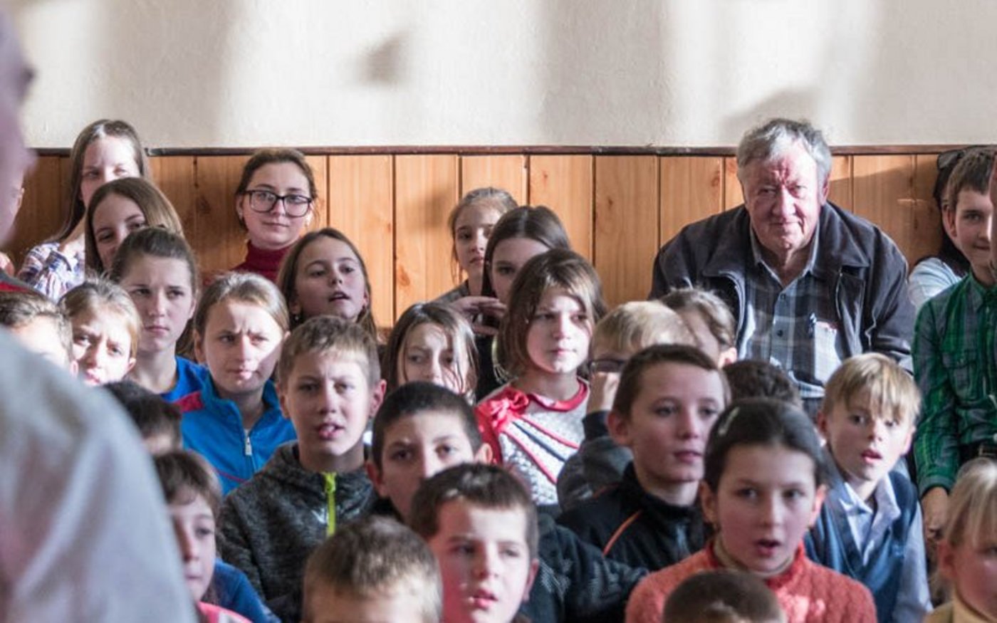 Peter Murri inmitten einer Schar Schüler. Er hat ihnen, wie jedes Jahr vor Weihnachten, ein kleines Geschenk gebracht.