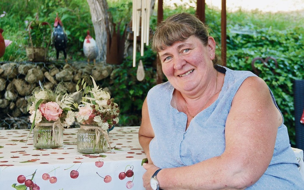Christa Tschan-Meury auf ihrem gemütlichen Sitzplatz. Die Blumendekoration auf dem Tisch haben die Bäuerinnen und Landfrauen Balsthal-Thal kreiert, für ihre GV 2022