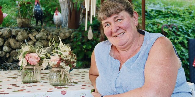 Christa Tschan-Meury auf ihrem gemütlichen Sitzplatz. Die Blumendekoration auf dem Tisch haben die Bäuerinnen und Landfrauen Balsthal-Thal kreiert, für ihre GV 2022