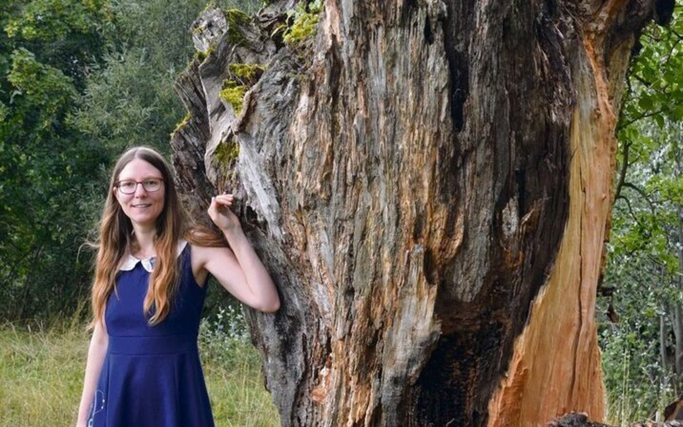 Tina Matzinger neben einem der Bäume, die von einem Sturm beschädigt wurden. Er darf stehen bleiben, da sich im Totholz Insekten ansiedeln.