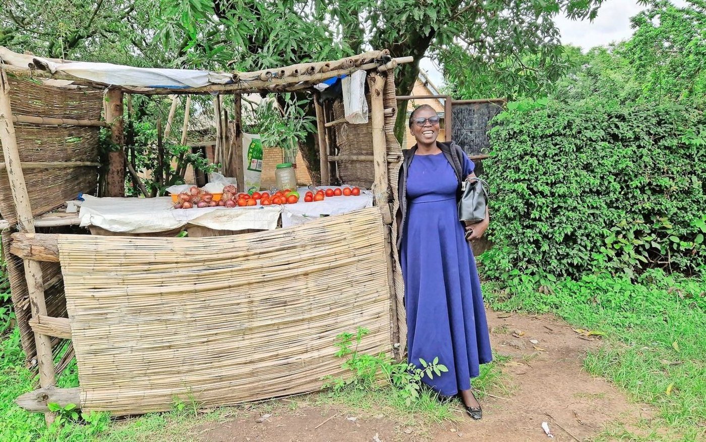 Belinda Zulu neben dem einfachen Gemüse-Kiosk, den sie neben dem Tor zum Grundstück eingerichtet hat. 