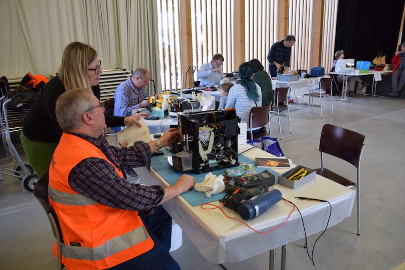 Bei diesem Kaffeeautomaten, der nicht mehr spült, war die erste Knacknuss das Öffnen des Gehäuses. Der Reparateur bekommt Unterstützung von der Besitzerin. (Bilder Esther Thalmann)