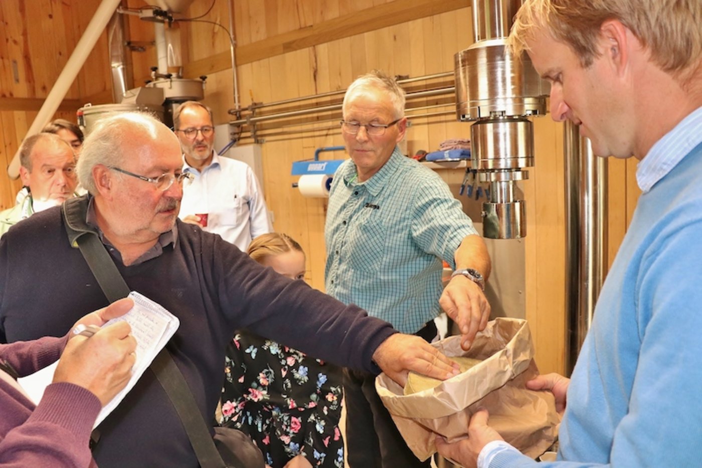 Interessiert begutachten Journalisten einen Presskuchen.
