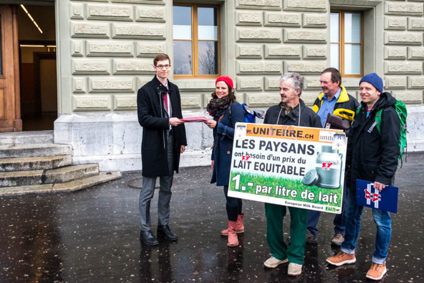 Berthe Derras überreicht einem Mitarbeiter der Bundeskanzlei die Unterschriften der Milchpetition. (Bild hja)