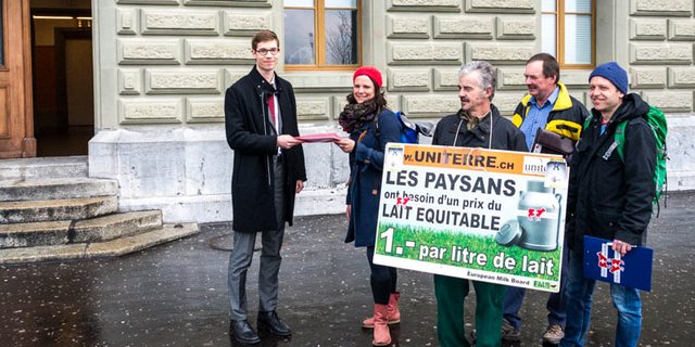 Berthe Derras überreicht einem Mitarbeiter der Bundeskanzlei die Unterschriften der Milchpetition. (Bild hja)