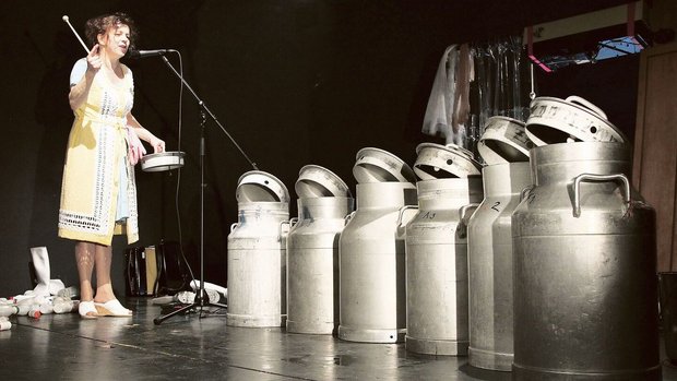 Charlotte Wittmer steht in ihrem Ein-Frau-Stück «Bränte» mit Milchkannen auf der Bühne.