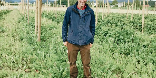 Simon Briner vor seinem Himbeerenfeld: Die Pfosten für das Schutzdach sind bereits eingeschlagen, auf die Blüte hin wird es fertiggestellt. Im Herbst schliesslich kommen Bäume für den Agroforst dazu.(Bild Alexandra Stückelberger)