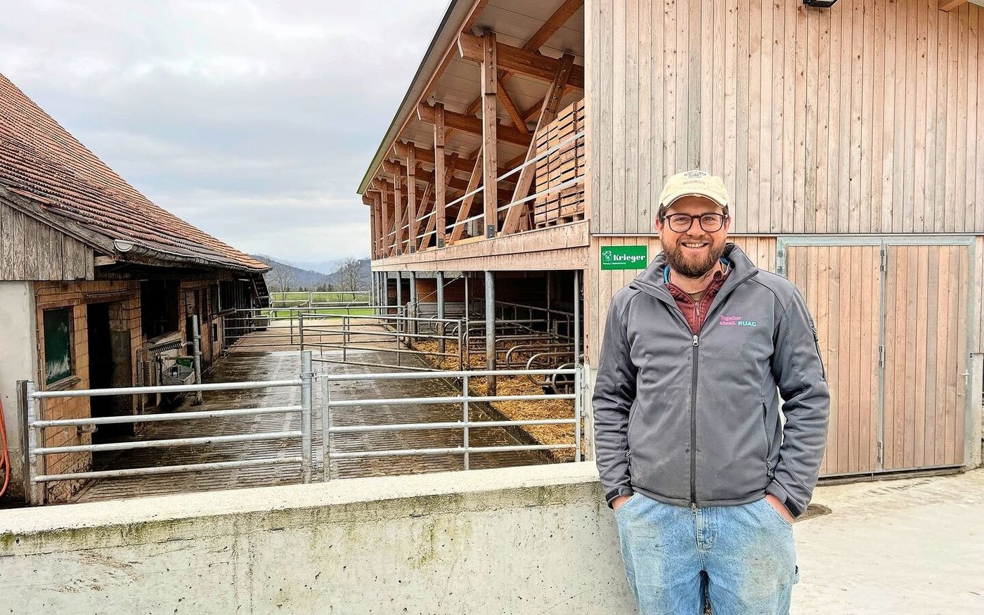 Christof Bühler vor dem Mutterkuhstall (vorne) und Pferdestall (hinten). Im alten Stall wurde nur innen investiert, und zwar in Liegeboxen, Fressachse und Abkalbebox.