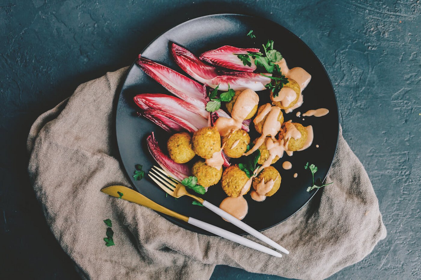 Sojabohnen-Falafel mit rosa Joghurt-Dressing auf Blattsalat
