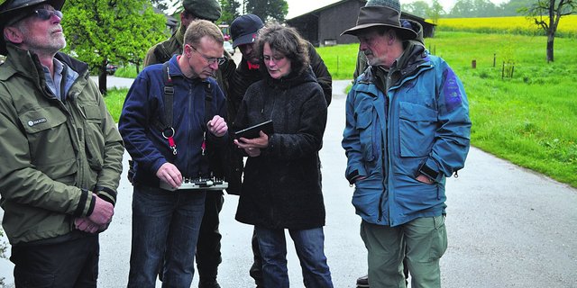 Nicole Berger zeigt ihrem Mann Walter auf dem Tablet das Flugbild, welches von der Drohne aus aufgenommen wird. Interessiert verfolgen Besucher des Hegekurses in Liestal den Drohnenflug. (Bild ai)
