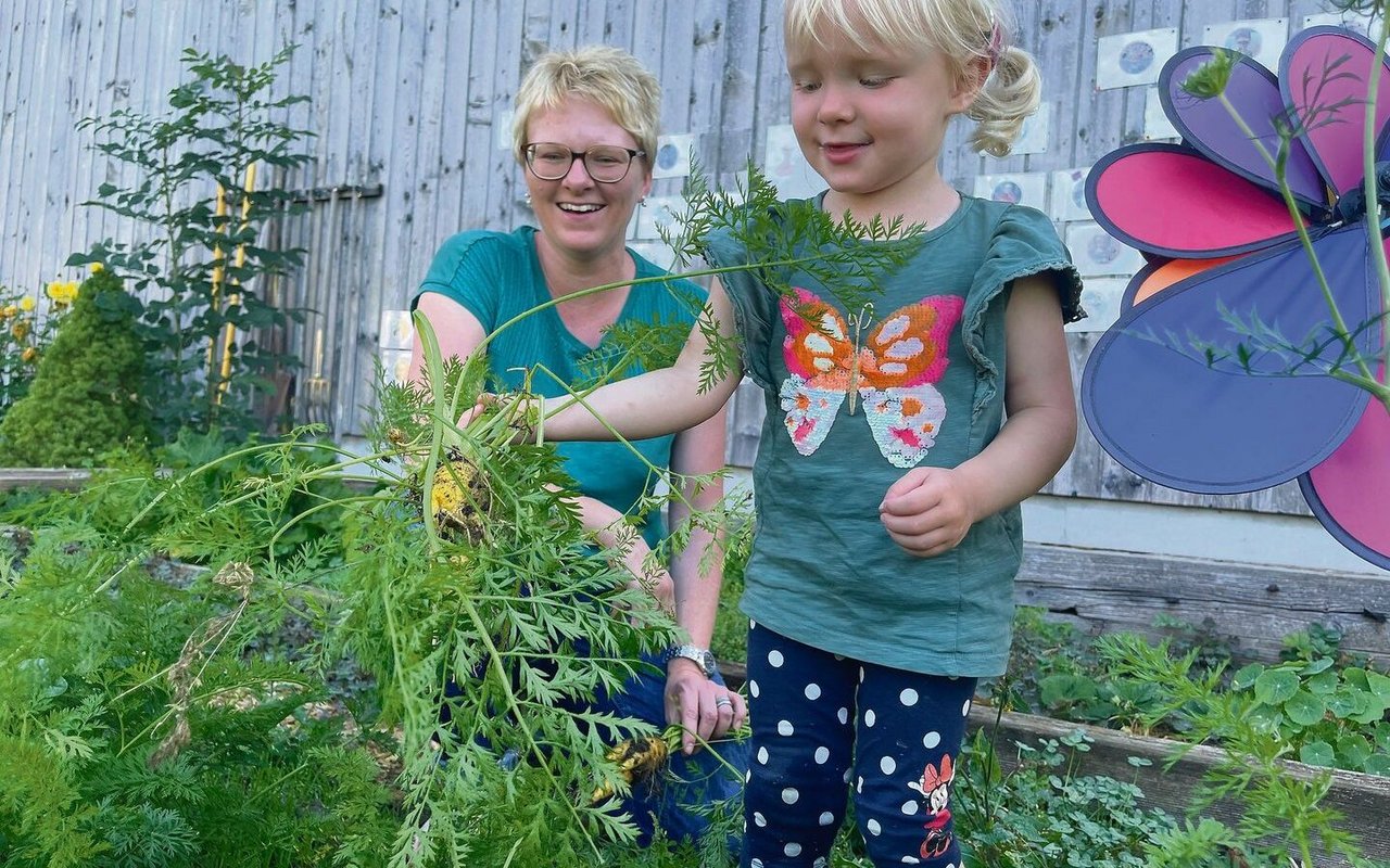 Yvonne Lustenberger mit Tochter Leonie im Garten der Spielgruppe. Hier lernen die Kinder etwa, dass Rüebli nicht «gruusig» sind, nur weil bei der Ernte noch Erde daran klebt.