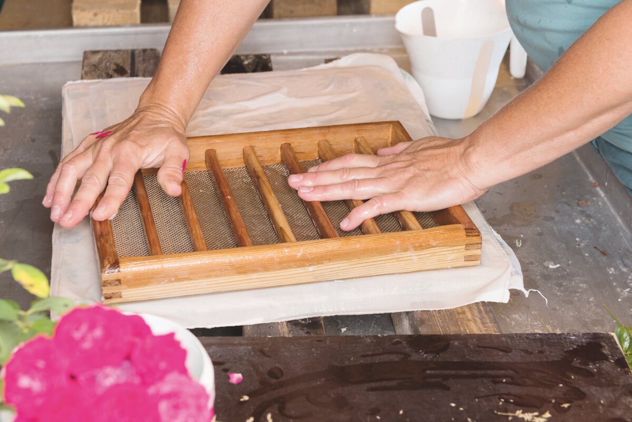 Patricia Müller in ihrem Element: nach dem Eintauchen in die Pulpe wird das Schöpfsieb gekippt, das Papier abgegautsch, gepresst und getrocknet. (Foto: Miriam Kolmann)