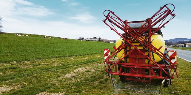 Mit einer improvisierten Einrichtung werden die Blumenbeete im Band gespritzt.(Bild Benno Jungo)