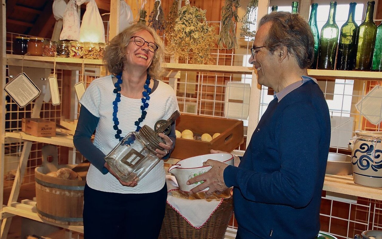 Susanne Grieder mit Butterglas und Viktor Ledermann mit einem Entrahmungsbecken freuen sich über die Ausstellung.