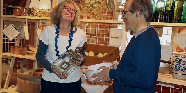 Susanne Grieder mit Butterglas und Viktor Ledermann mit einem Entrahmungsbecken freuen sich über die Ausstellung.