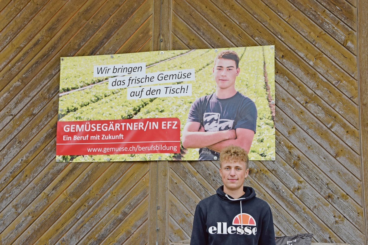Merlin Berner  vor einem der Plakate, mit denen der Verband Schweizer Gemüseproduzenten schweizweit Werbung für den Lehrberuf Gemüsegärtner(in) machte.