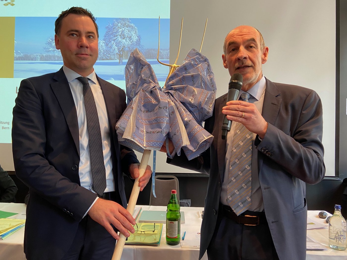 Jacques Bourgeois überreicht Martin Rufer (l.) eine Heugabel als Präsent. (Bild akr)