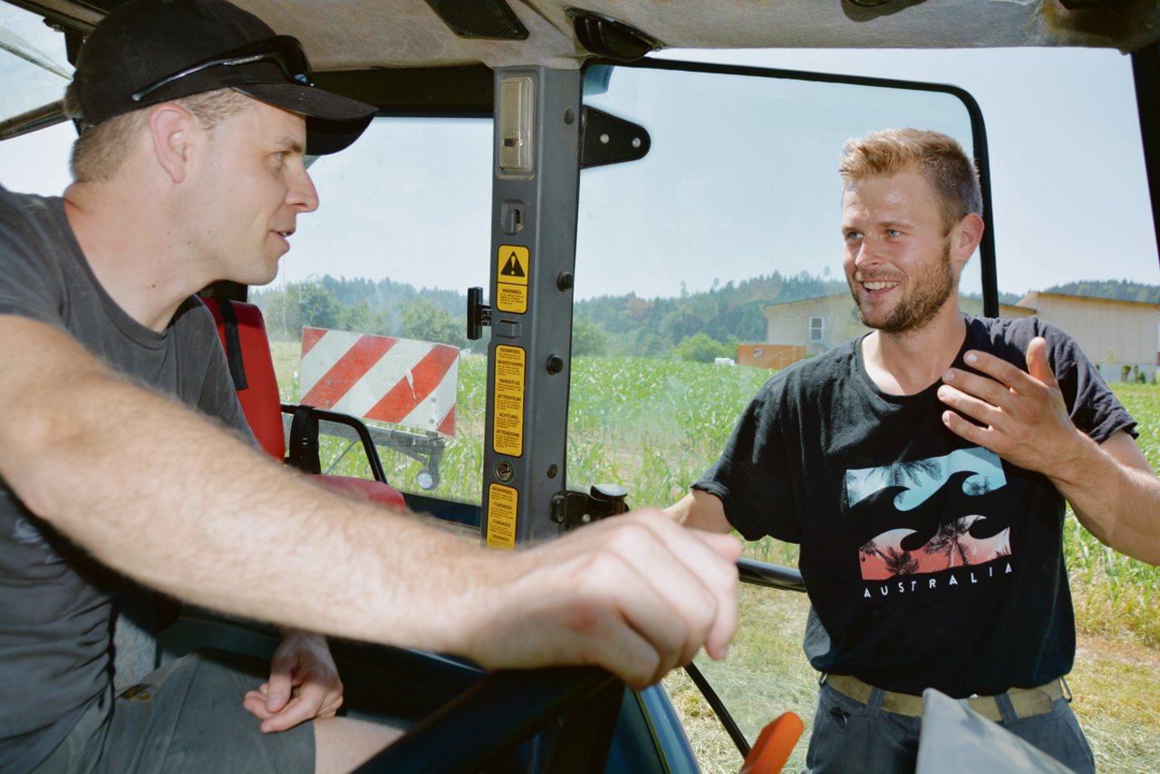 Volle Konzentration: Landwirt Martin Meier (rechts) erklärt Versicherungsberater Adrian Furrer vom LBV auf dem Traktor den Einsatz mit dem Kreiselheuer.(Bilder Armin Emmenegger)