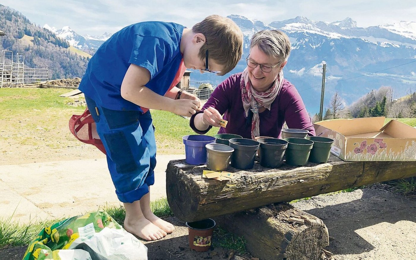 Edith Camenzind mit ihrem jüngsten Sohn Felix. Sie pflanzen gemeinsam Sonnenblumen. 