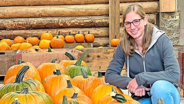 Sandra Reinhard, ein Sandra Reinhard, eine der beiden Betriebsleiterinnen des Iltishofs, inmitten von Kürbissen.
