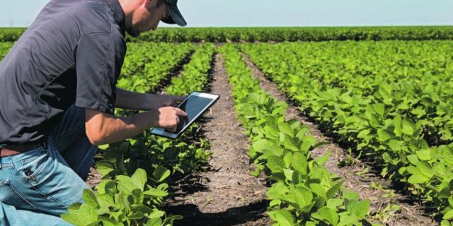 Landwirt mit modernem Arbeitsgerät. Trotz Digitaleuphorie gilt aber unverändert: Ohne Kuh keine Milch, ohne geeignete Unterlage und gutes Saatgut kein anständiger Ertrag.  (Bild Shutterstock)