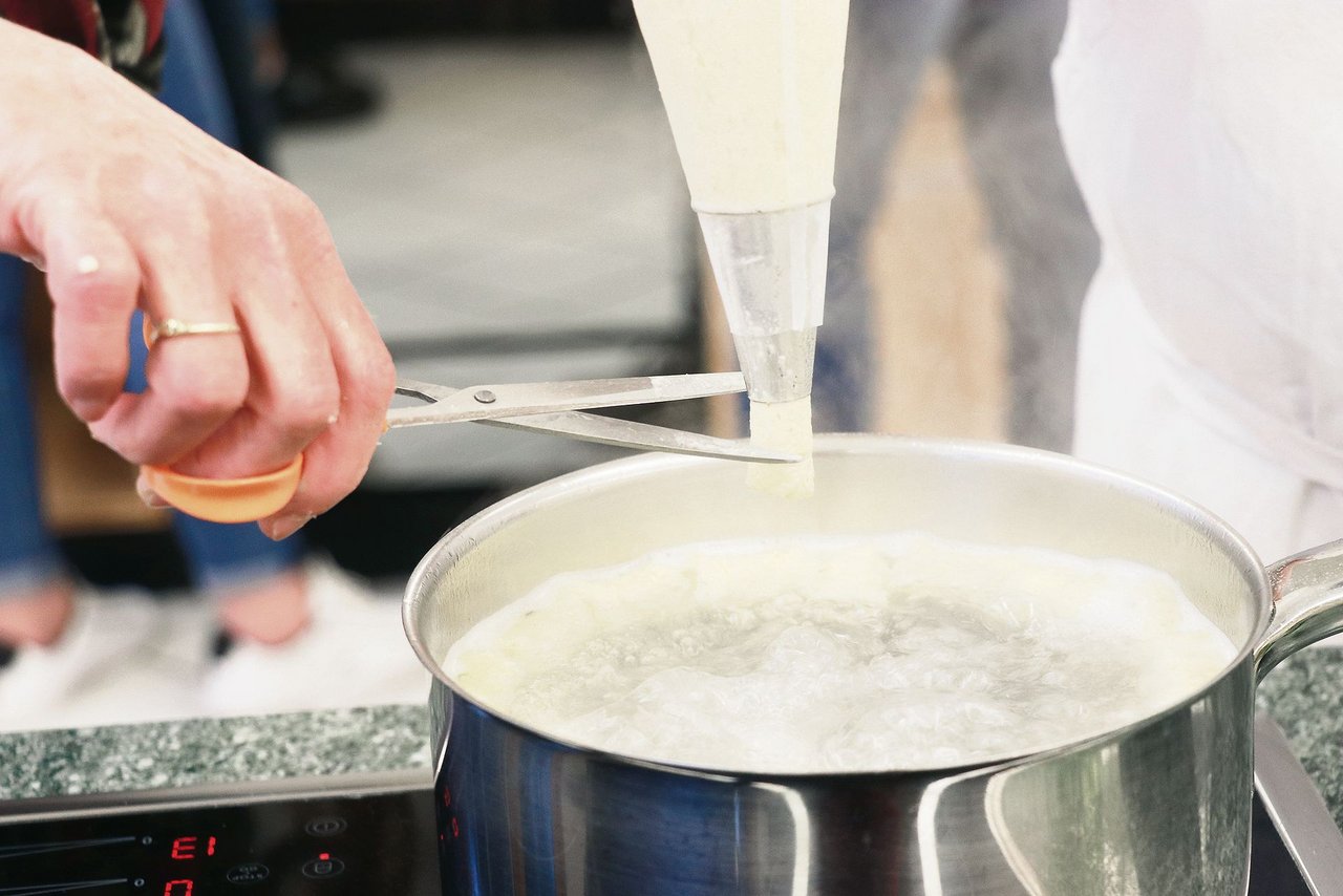 Aus Eiern, Flüssigkeit, Mehl und Salz entsteht der Teig. Oben rechts ist das Knöpflisieb im Einsatz, unten links werden Gnocchi mit der Schere aus dem Spritzsack ins kochende Wasser portioniert. Es gibt schnellere Mahlzeiten – aber das Resultat überzeugt.