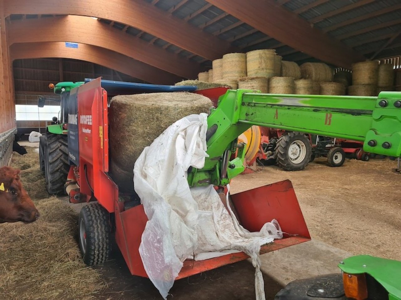 Ballen können mit der hydraulischen Ladeklapppe aufgenommen werden oder – wie hier – mit einem Lader direkt auf den Kratzboden gestellt werden.