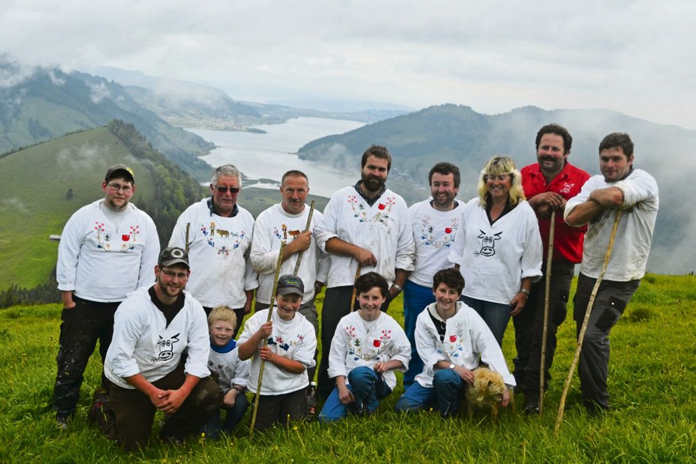 Die Helferinnen und Helfer beim Alpaufzug mit dem Betriebsleiterehepaar René und Astrid Späni (hintere Reihe Zweiter und Dritte v. r.). Vater Walter Späni (hintere Reihe Zweiter. v. l.) wird das Vieh im Sommer auf der Alp betreuen. Im Hintergrund ist der Sihlsee gut sichtbar.