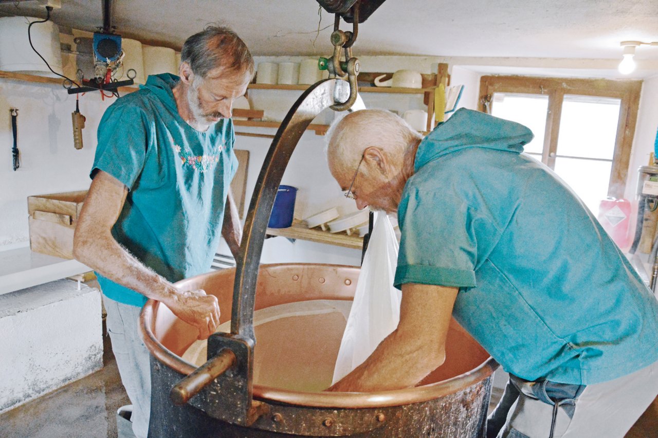 Bild links: Walter von Holzen (links) und Fridolin Jöhl beim Käsen. Mitte: Die Käseformen werden mit Gewichten beschwert. Rechts: Die Käsetücher werden sofort nach Gebrauch ausgewaschen.