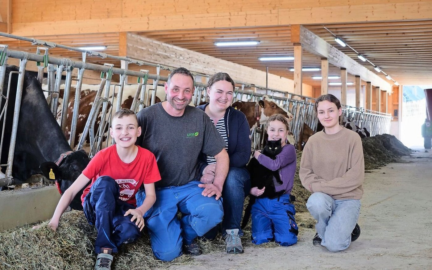 Michael und Katrin Stalder mit ihren Kindern Manuel, Salome und Lena (v.r.n.l.) im neu gebauten Laufstall. Dank der neuen Technik wie Melk- und Mistroboter bleibt nun mehr Zeit für die Familie.