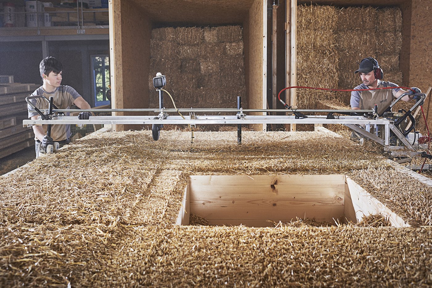 Zurechtschneiden der Strohballen in der Konstruktion. (Bild Atelier Schmidt)