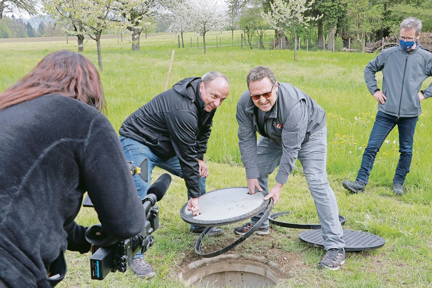 Regierungsrat Markus Dieth (links) und Landwirt Daniel Habegger haben die Aktion Schachtdeckel offiziell gestartet, beobachtet von Medien und Matthias Müller, Landwirtschaft Aargau (rechts). (Bild Ruth Aerni)