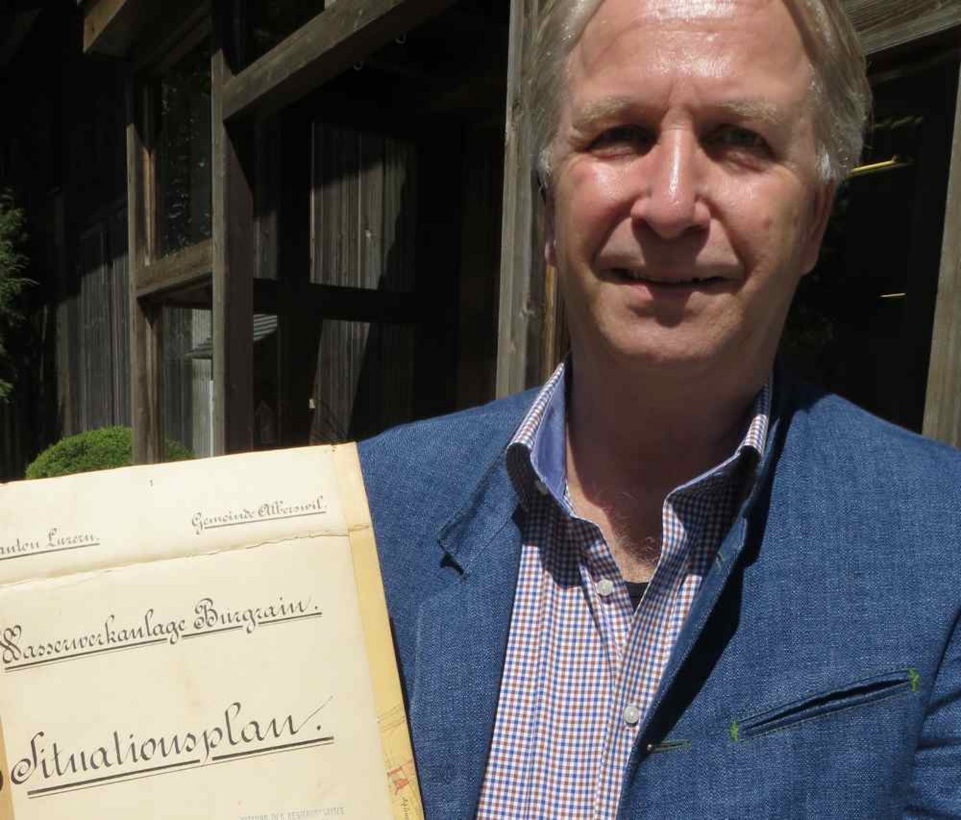 Paul Fuchs als neuer Eigentümer der sanierungsbedürftigen Burgrain-Mühle zeigt einen historischen Übersichtsplan von anno 1897 mit den Gewässern im Burgrain. (Bild Alois Hodel)