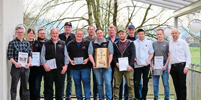 Die geehrten Züchterinnen und Züchter mit ihren Auszeichnungen. Mittendrin steht Christoph Rohrbach mit seiner Auszeichnung (Holzuhr) für seine 100 000er-Kuh Iatola India und ganz rechts Präsident André Stalder.