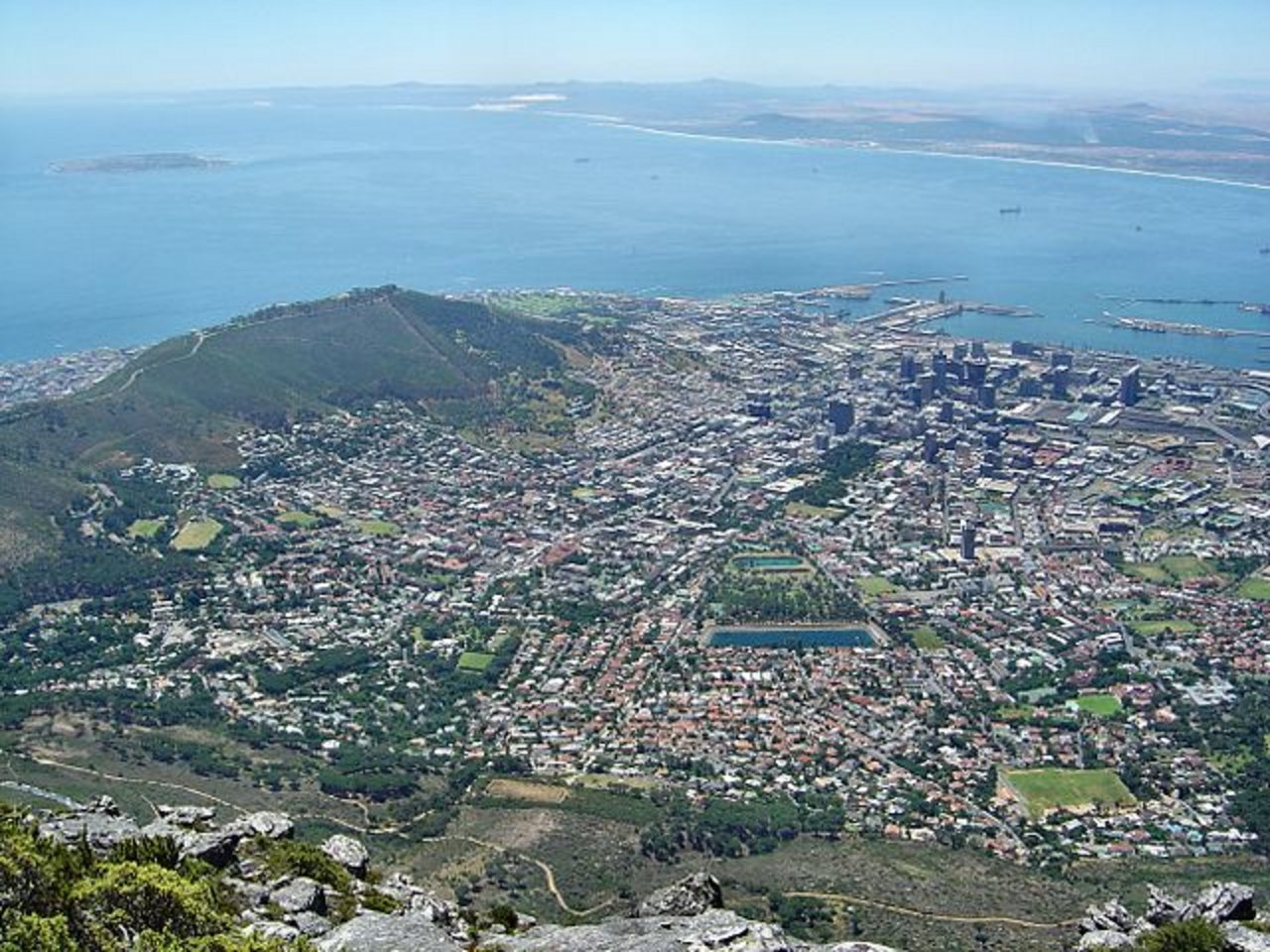 Blick auf Kapstadt mit dem Waterfront Harbour und Robben Island vom Tafelberg aus. (Bild Andreas Tusche - Wikimedia)