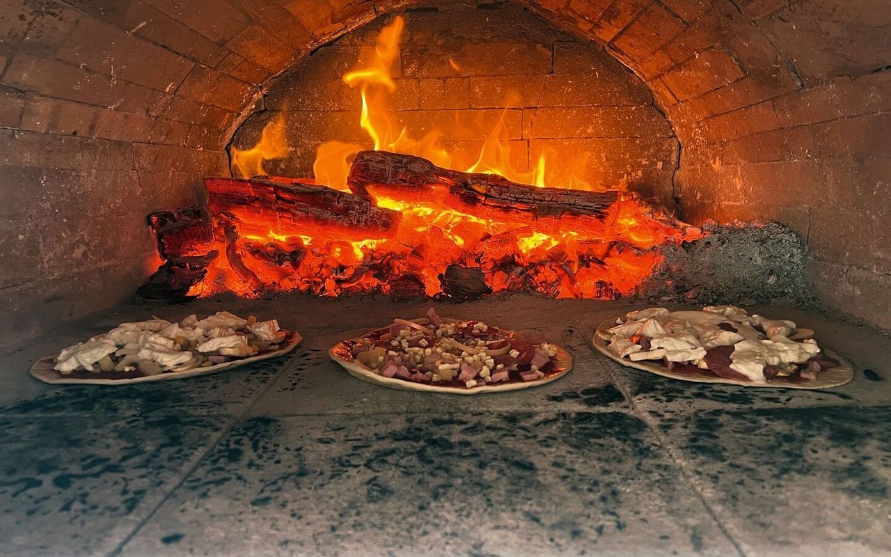 Pizze werden im Holzofen gebacken.
