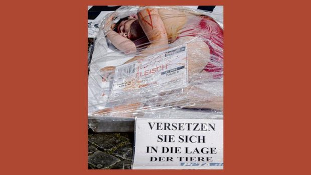 Ein Aktivist hat sich bei einer Demonstration in Basel als Fleischstück in Cellophan gewickelt. Mit solchen Aktionen verschafft sich Peta Aufmerksamkeit. (Bild Keystone/Andreas Frossard)
