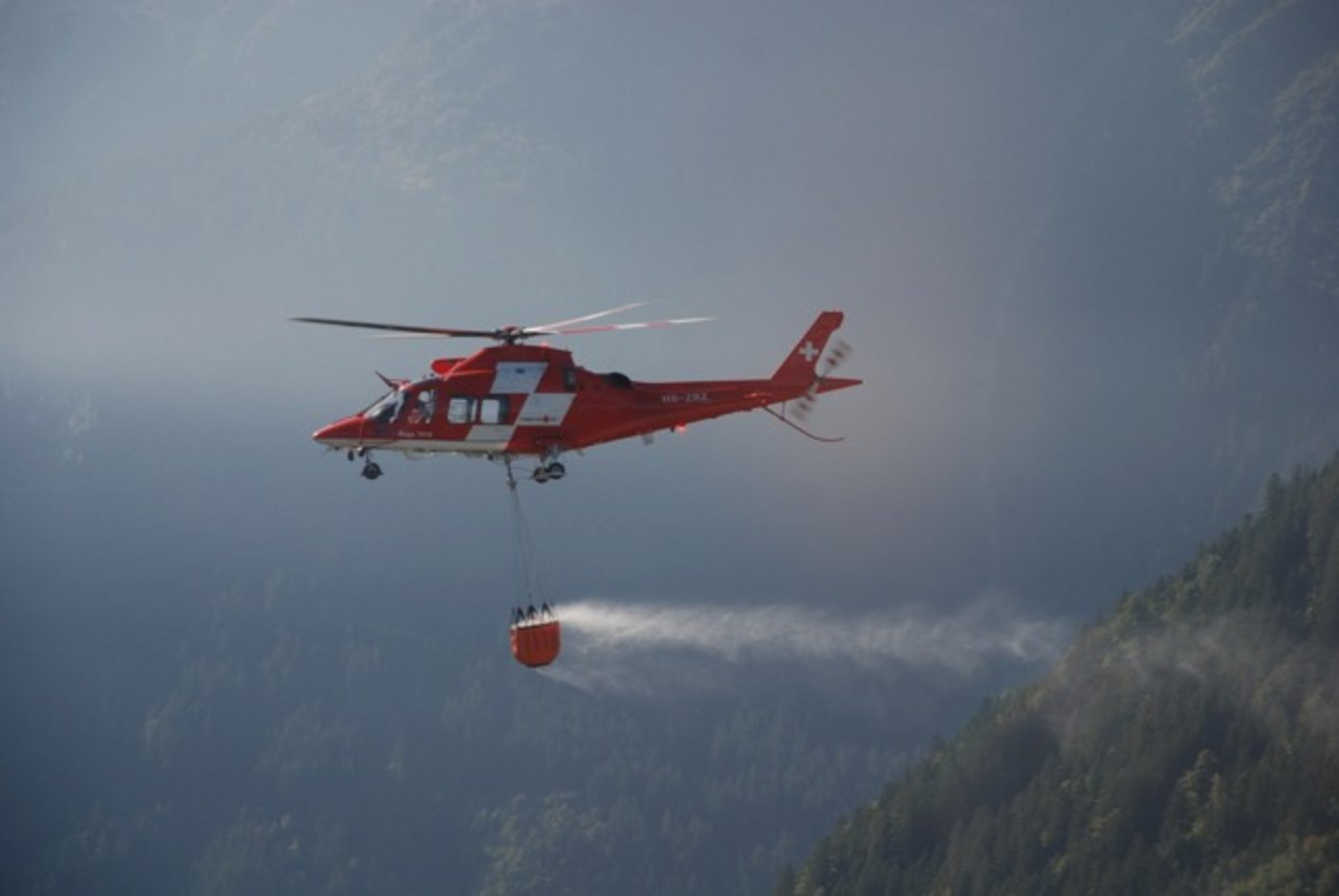 Der Helikopter löschte den Brand mit Wasser aus dem angehängten Bambi-Bucket. (Bild Kapo SG)