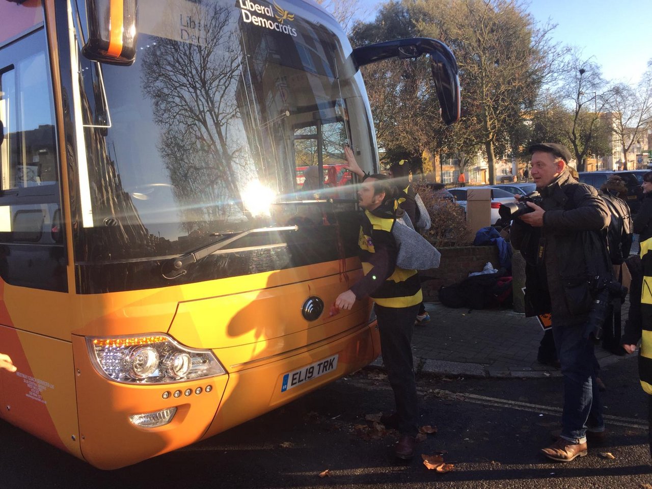 Ein als Biene verkleideter Aktivist hat sich an den Bus der englischen Politikerin Jo Swinson geleimt. (Bilder Extinction Rebellion)