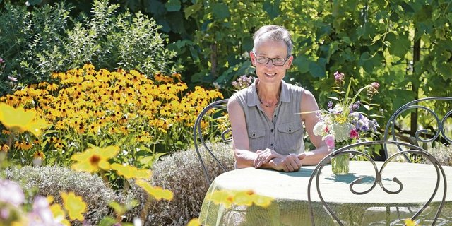 Im Naturgarten von Elisabeth Gebhard gibt es mehrere Sitzplätze. Fürs Foto setzt sie sich hin, ansonsten ist sie meist in Bewegung – den Garten geniesst sie trotzdem. 