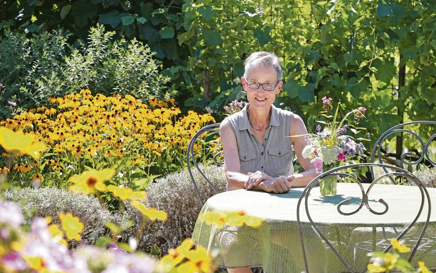 Im Naturgarten von Elisabeth Gebhard gibt es mehrere Sitzplätze. Fürs Foto setzt sie sich hin, ansonsten ist sie meist in Bewegung – den Garten geniesst sie trotzdem. 